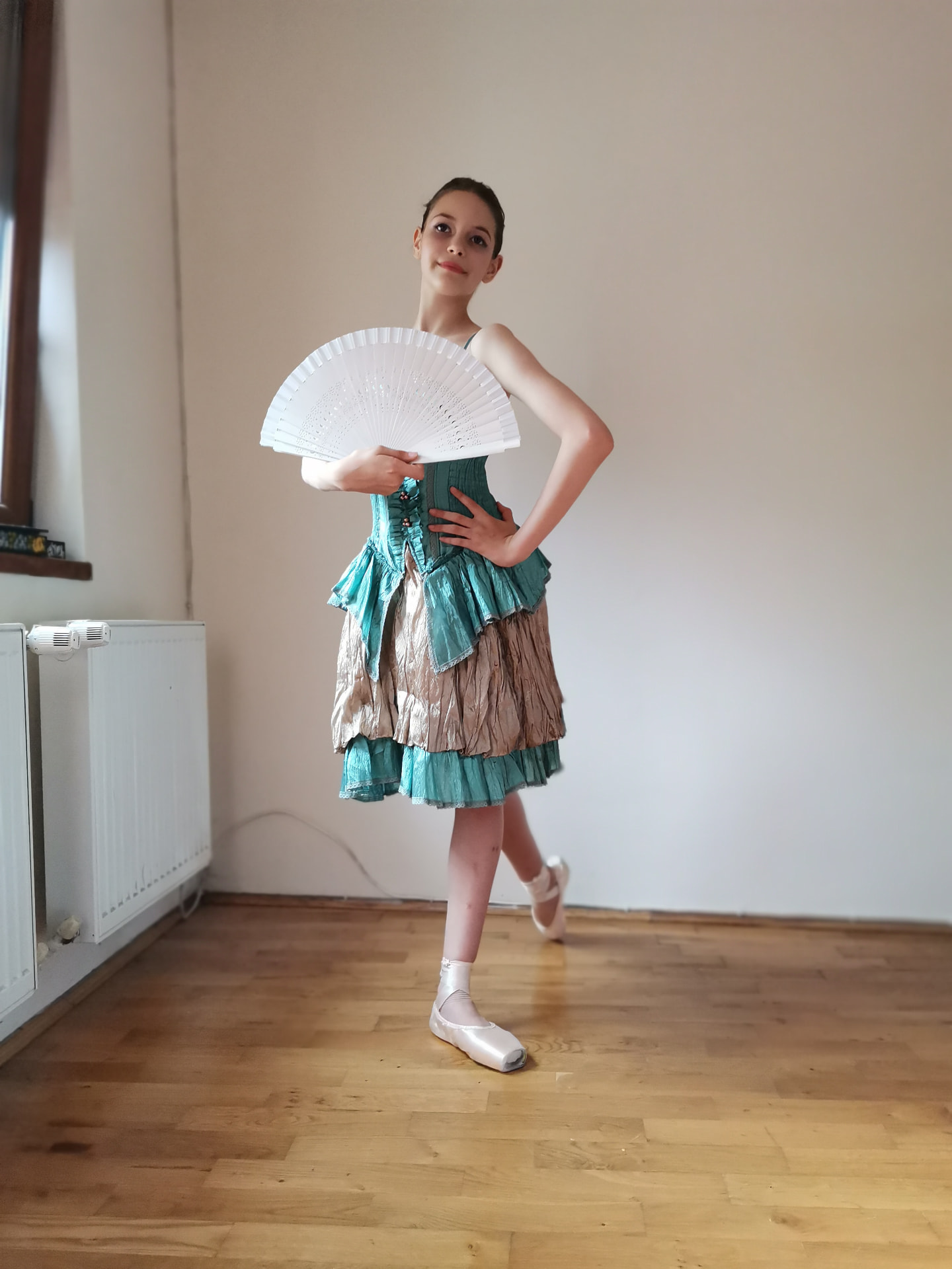 Tânără balerină în costum de scenă cu evantai alb